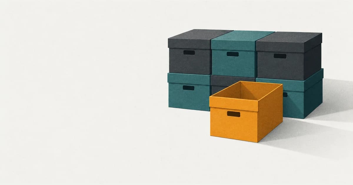 A stack of closed boxes in shadow, with one box pulled forward into the light so you can see it is empty.